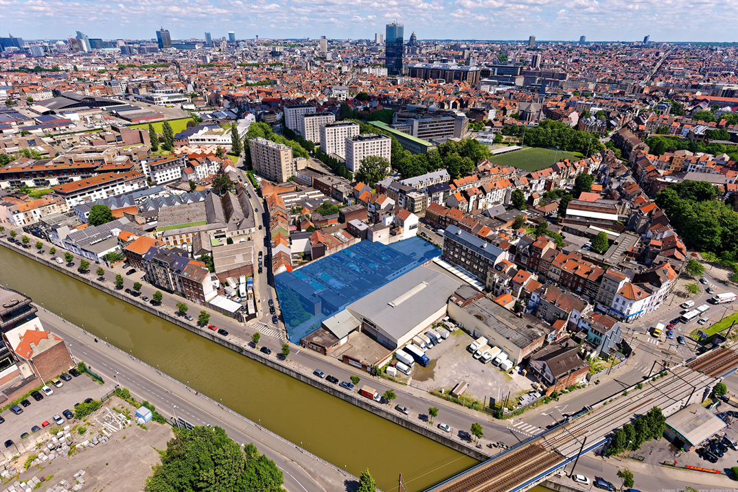 Luchtfoto van de site, met het stadscentrum op de achtergrond.